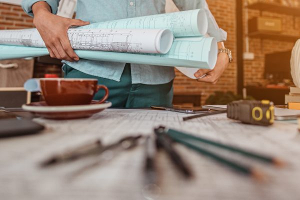 Male architect are holding on blueprint and helmet working engineering or architecture project to come out completely. Engineer, Engineering, Architecture, Blueprint, Planning, Occupation concept.